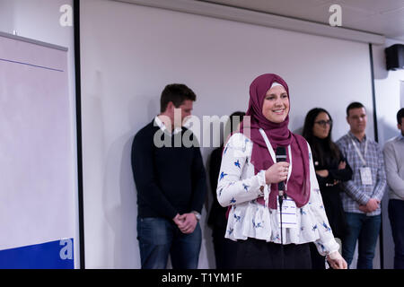 young muslim businesswoman with red scarf at business conference room giving public presentations. Audience at the conference hall. Entrepreneurship c Stock Photo