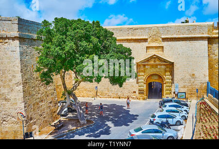 MDINA, MALTA - JUNE 16, 2018: The outer wall of Mdina fortress with a view on historical Greek Gate, decorated with carved decorations, on June 16 in  Stock Photo