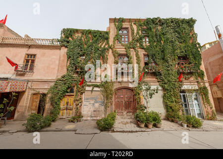 House in Kashgar Old Town. The photo was captured during Chinese National Holiday, so there are Chinese flags on every corner of the house Stock Photo