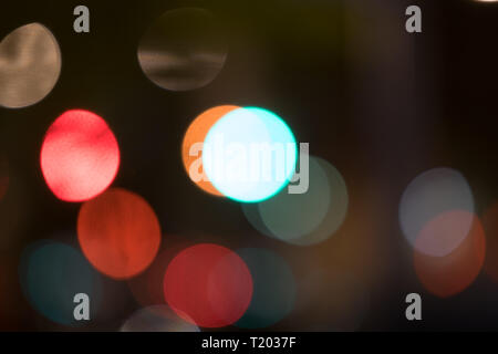 Abstract multicolored bokeh balls floating across a dark background Stock Photo