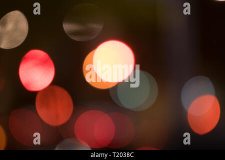 Abstract multicolored bokeh balls floating across a dark background Stock Photo