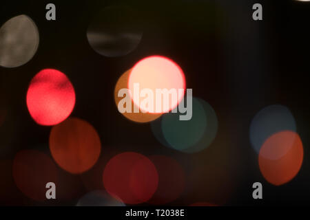 Abstract multicolored bokeh balls floating across a dark background Stock Photo
