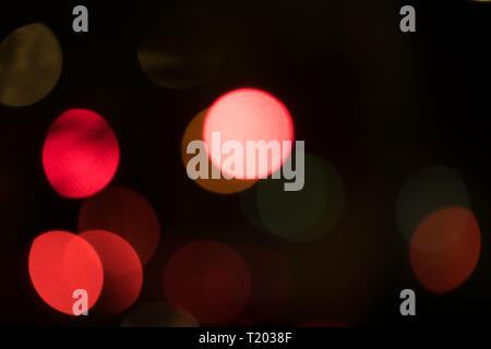 Abstract multicolored bokeh balls floating across a dark background Stock Photo