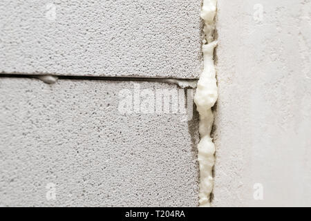 foam-filled joint between aerated concrete blocks, close-up Stock Photo