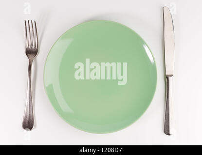 empty green plate with fork and knife isolated on white background, top view Stock Photo