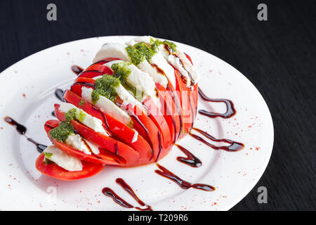 Caprese salad. Mozzarella Cheese With Tomatoes And Pesto Sauce. Stock Photo