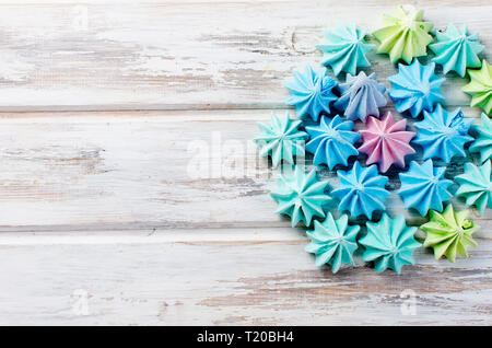 Blue and green  colored french meringues , on white wooden background. Copy space. Stock Photo