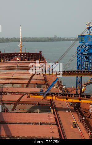 Ore Loading Platform Workers load ore on a cargo train in a yard of bauxite imported from ...