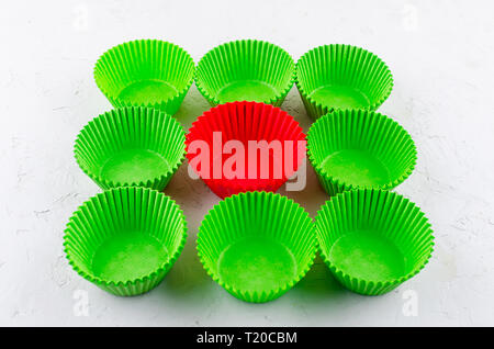 Brightly green and red colored paper baking cups for cupcakes or muffins on light grey conkrete background, copy space Stock Photo