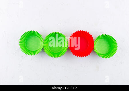 Brightly green and red colored paper baking cups for cupcakes or muffins on light grey conkrete background, copy space Stock Photo