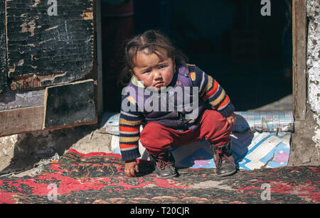 bayan Ulgii, Mongolia, 1st October 2015: mongolian nomad kid playing at the doorstep of her home Stock Photo