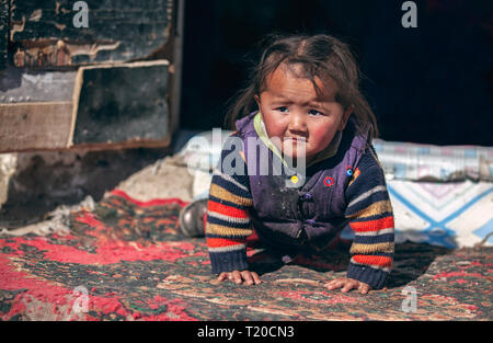 bayan Ulgii, Mongolia, 1st October 2015: mongolian nomad kid playing at the doorstep of her home Stock Photo