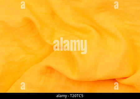 close up crumpled orange cotton fabric background Stock Photo