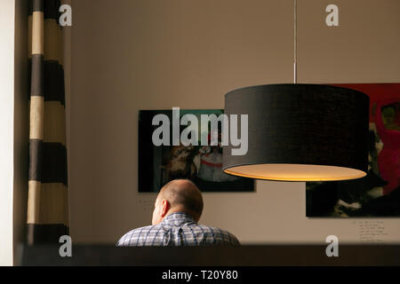 Seated man in a hotel lounge looking out of window Stock Photo