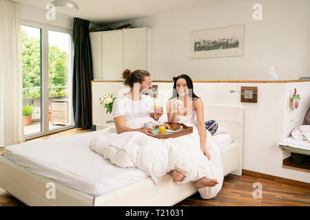 Affectionate couple having breakfast in bed Stock Photo