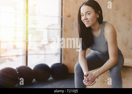 young girl in sportswear in a gym in a simple background, a theme of fitness, and sport, a healthy lifestyle Stock Photo