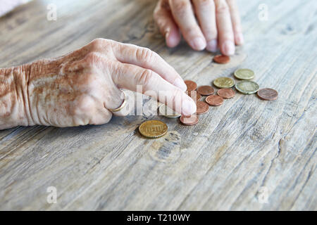 Hand of senior woman counting coins, close-up Stock Photo