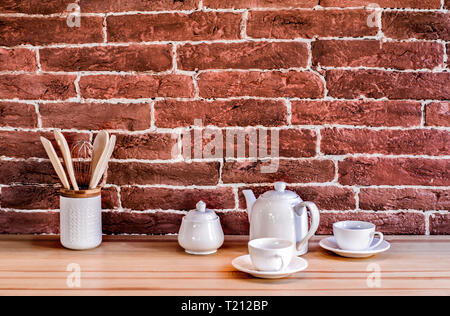 Fragment of kitchen interior on a brick wall background with kitchen utensils. Stock Photo