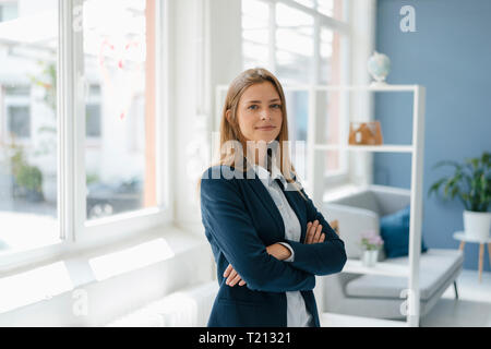 Portrait of a confident young businesswoman, standing in office Stock Photo