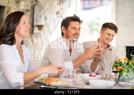 Happy family having meal together Stock Photo