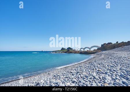 Beautiful scenic of Sanxiantai arch bridge with blue ocean with Three saint island in behind at Chenggong district in Taitung city, Taiwan. Stock Photo