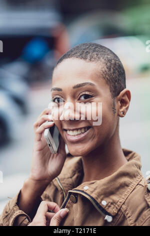 An Afro-Brazilian woman in Sao Paulo using her phone in the street Stock Photo