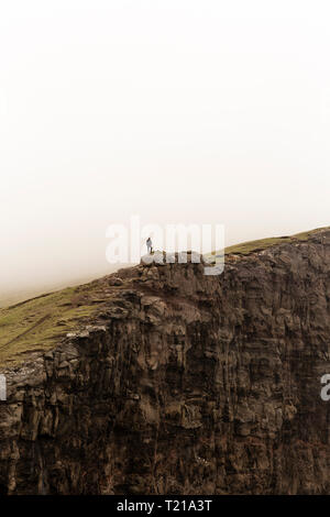 Man standing on edge of big cliff Stock Photo