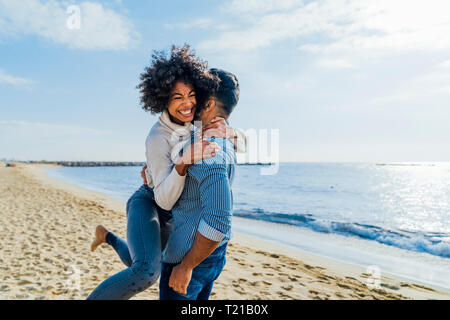 Spain, Barcelona, happy couple hugging on the beach Stock Photo