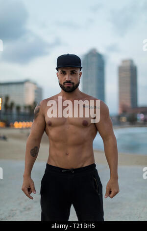 Portrait of barechested muscular man outdoors at dusk Stock Photo
