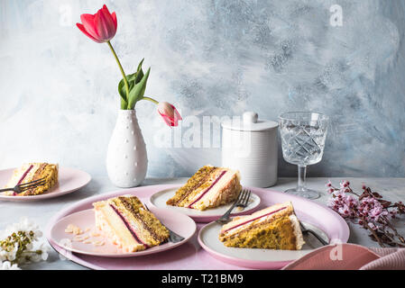Slices of chocolate mousse cake on a  plates and a tulip flowers in a white vase Stock Photo