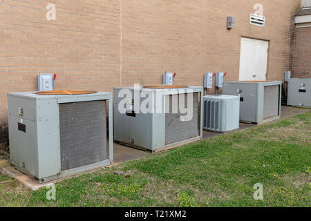 Commercial Air Conditioner compressors outside of brick building Stock Photo