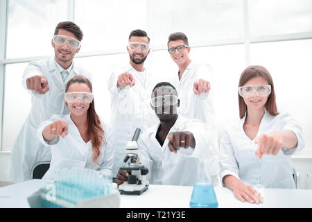 Group of young successful scientists posing for camera Stock Photo