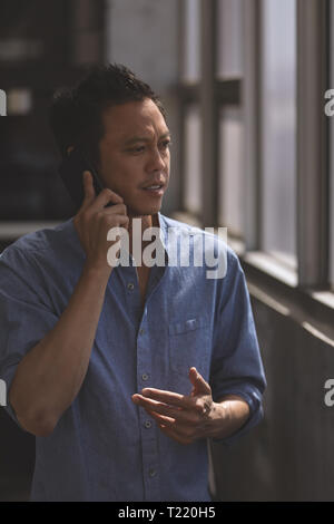 Male executive talking on mobile phone in the office Stock Photo
