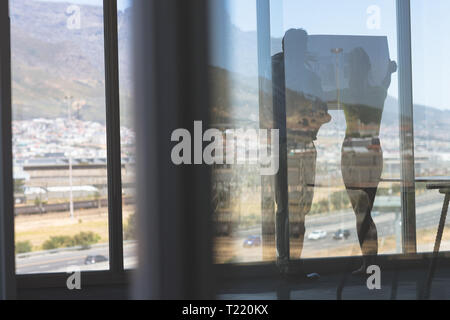 Male and female architects discussing over blueprint in the office Stock Photo