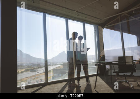 Architects discussing over blueprint in office Stock Photo