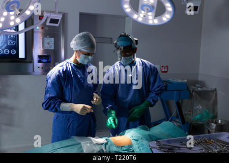 Surgeons performing operation in operating room in hospital Stock Photo