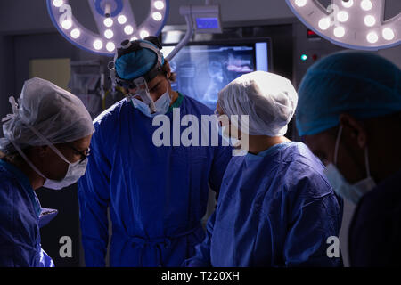 Surgeons talking with each other during surgery in operating room at hospital Stock Photo