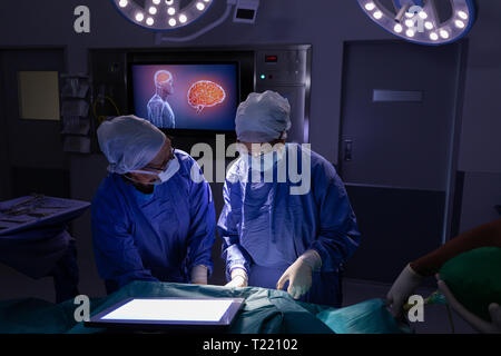 Surgeons performing operation in operating room at hospital Stock Photo