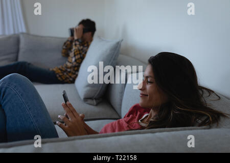Woman using mobile phone while man using virtual reality headset Stock Photo