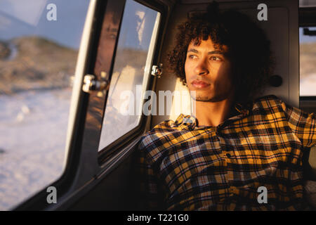 Thoughtful man sitting in a camper van Stock Photo