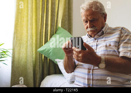 Senior man using mobile phone at nursing home Stock Photo