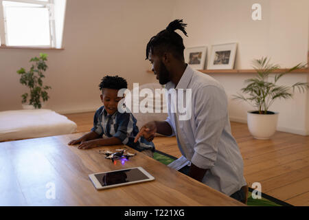 Father and son playing with drone on table Stock Photo