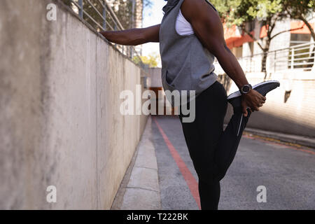 Man doing stretching exercise on street Stock Photo