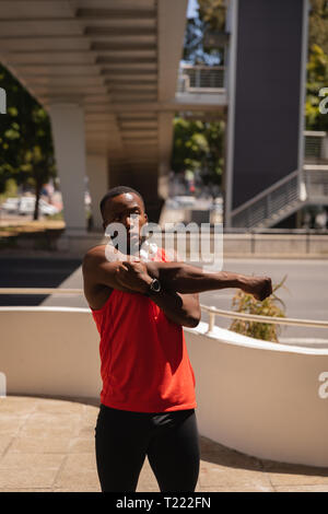 Man doing hand stretch exercise at pavement under the bridge Stock Photo