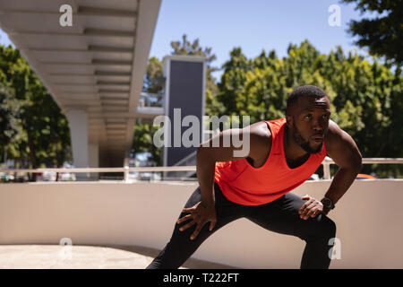 Young man doing exercise under the bridge on a sunny day Stock Photo