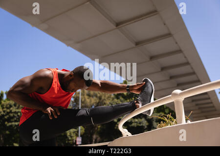 Young man doing exercise under the bridge on railing Stock Photo