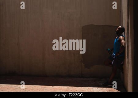 Man standing beside the wall on a sunny day Stock Photo