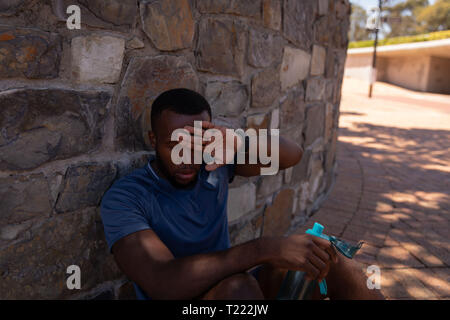 Man relaxing beside wall on a sunny day Stock Photo