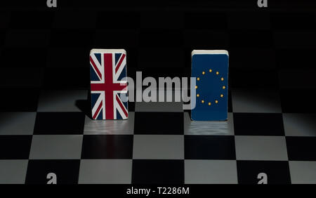 Backlit in the shadows figures and flags of the European Union and Great Britain on the chessboard. The concept of the political game and chess strate Stock Photo