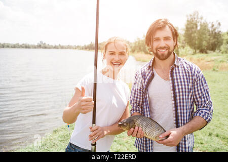 Cheerful multicultural men in fishing outfit holding thermo cups near lake  Stock Photo - Alamy